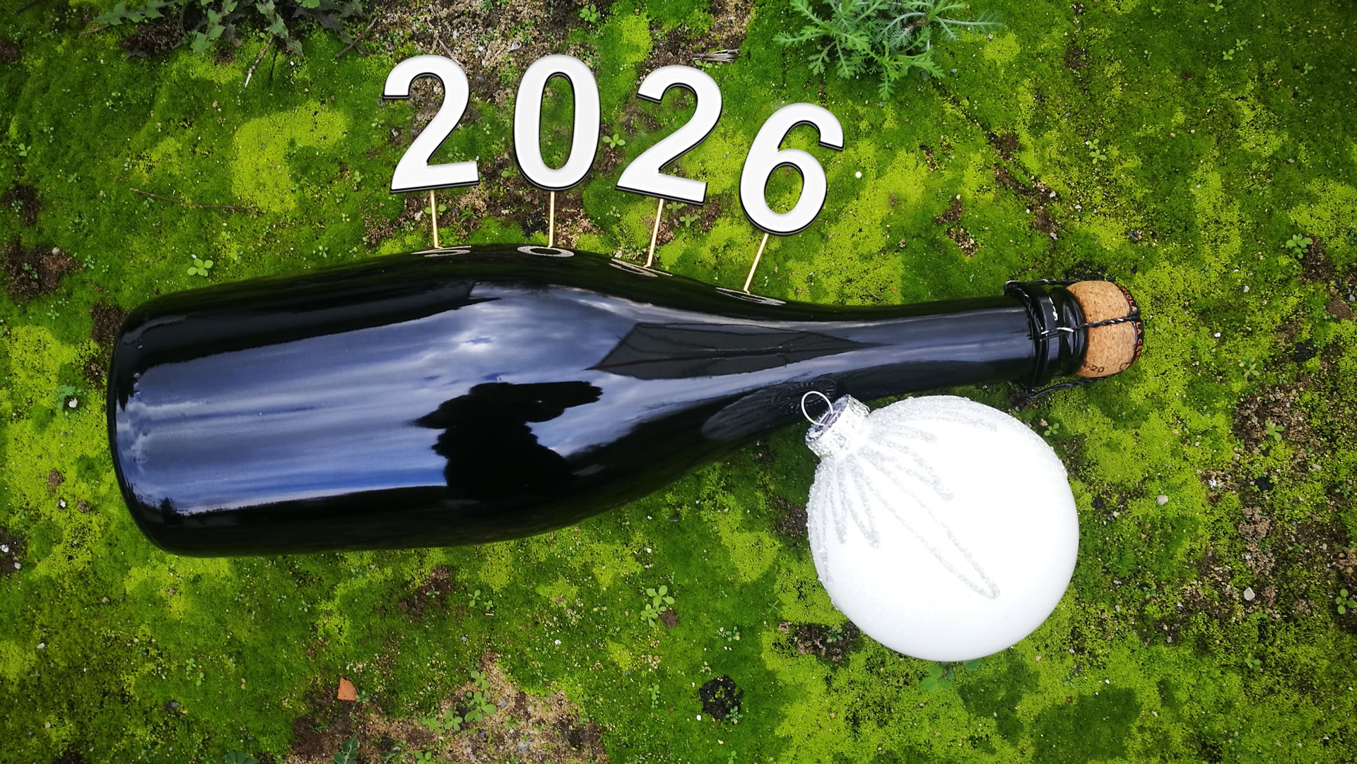 Photo sur un tapis de mousse verte avec une bouteille de champagne avec 2027